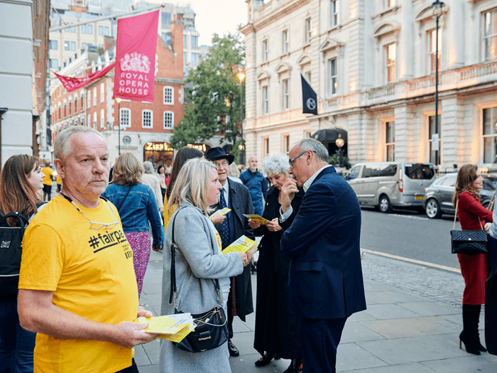 A person in a bright yellow t-shirt reading 